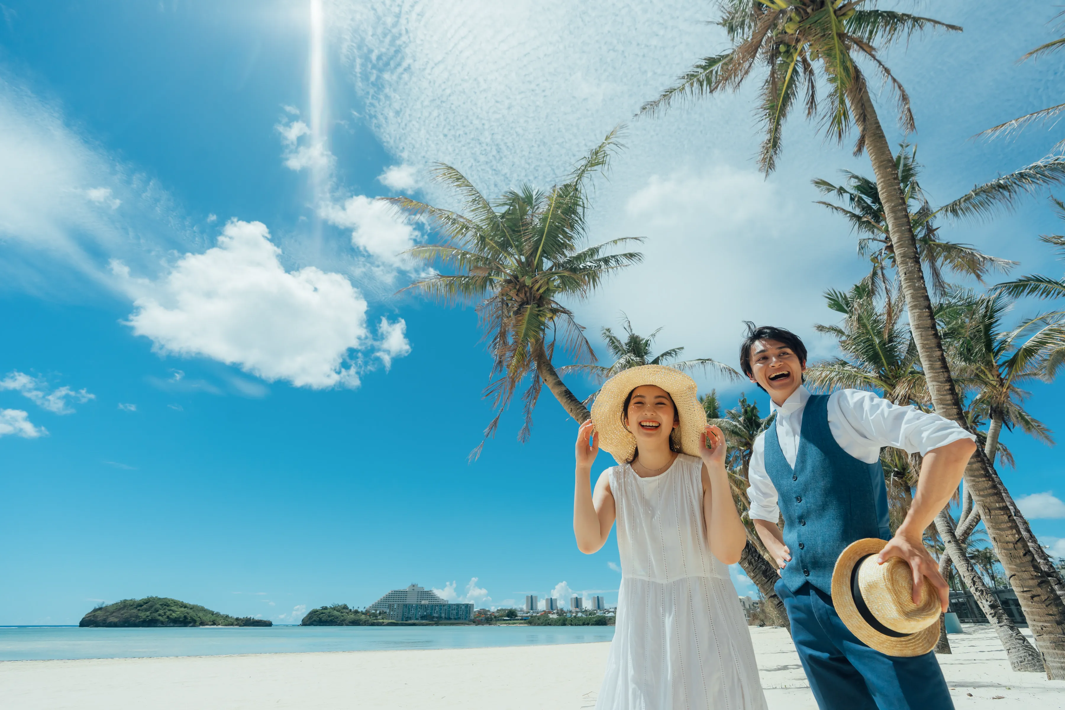 グアムの海辺を歩く新郎新婦のリゾートウェディング風景