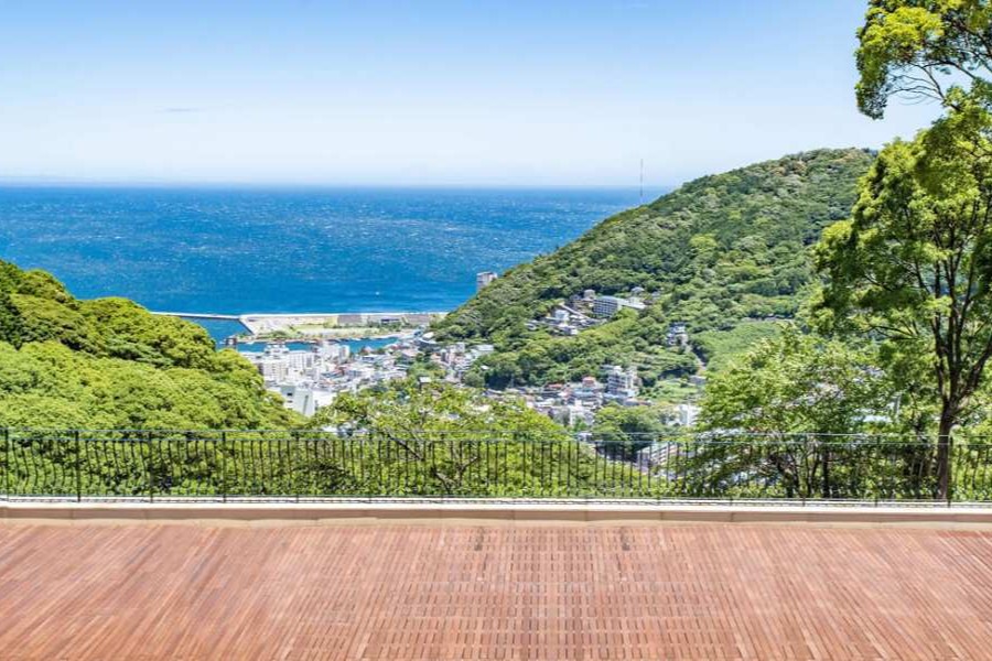 【海と山に包まれる絶景のオーシャンビュー挙式】高台に佇む邸宅リゾートからは、相模湾と緑豊かな山々を一望でき、 ウッドデッキでの挙式はまるで海外リゾートのような開放感。 海を背景にしたフォトは美しく、サンセットの時間帯は特に人気です。