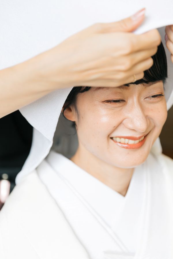 今治城内鎮座 吹揚神社で挙げられたお客様の結婚式写真　綿帽子をつけてお仕度をしている白無垢姿の新婦様