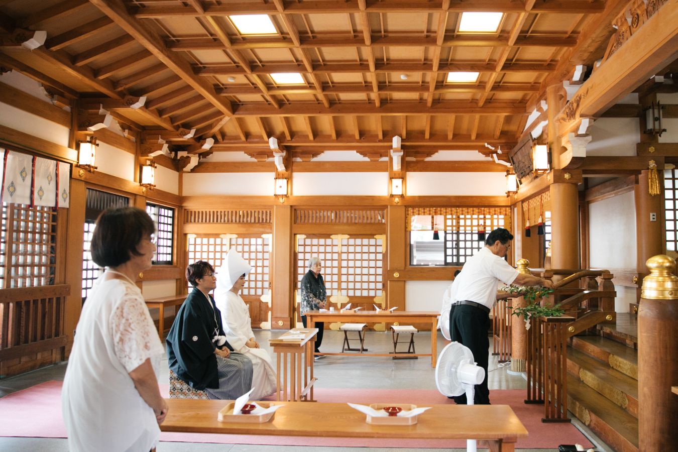 今治城内鎮座 吹揚神社で挙げられたお客様の結婚式写真　神前式で代表玉串奉奠を行うご両家お父様とそれを見守る紋付袴姿の新郎様と白無垢綿帽子をつけた新婦様