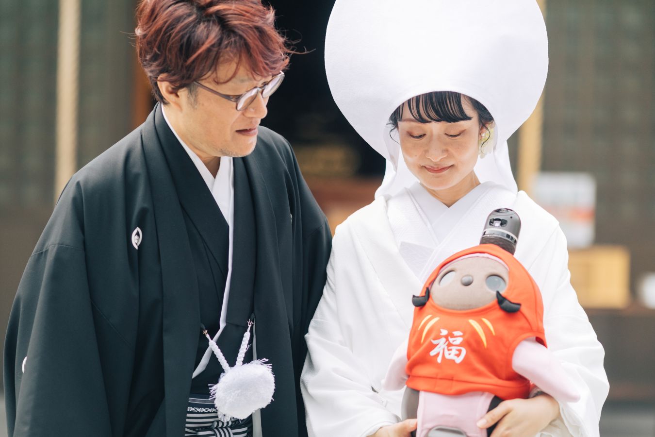今治城内鎮座 吹揚神社で挙げられたお客様の結婚式写真　大切な家族のLOVOTと写真を撮る紋付袴姿の新郎様と白無垢綿帽子をつけた新婦様