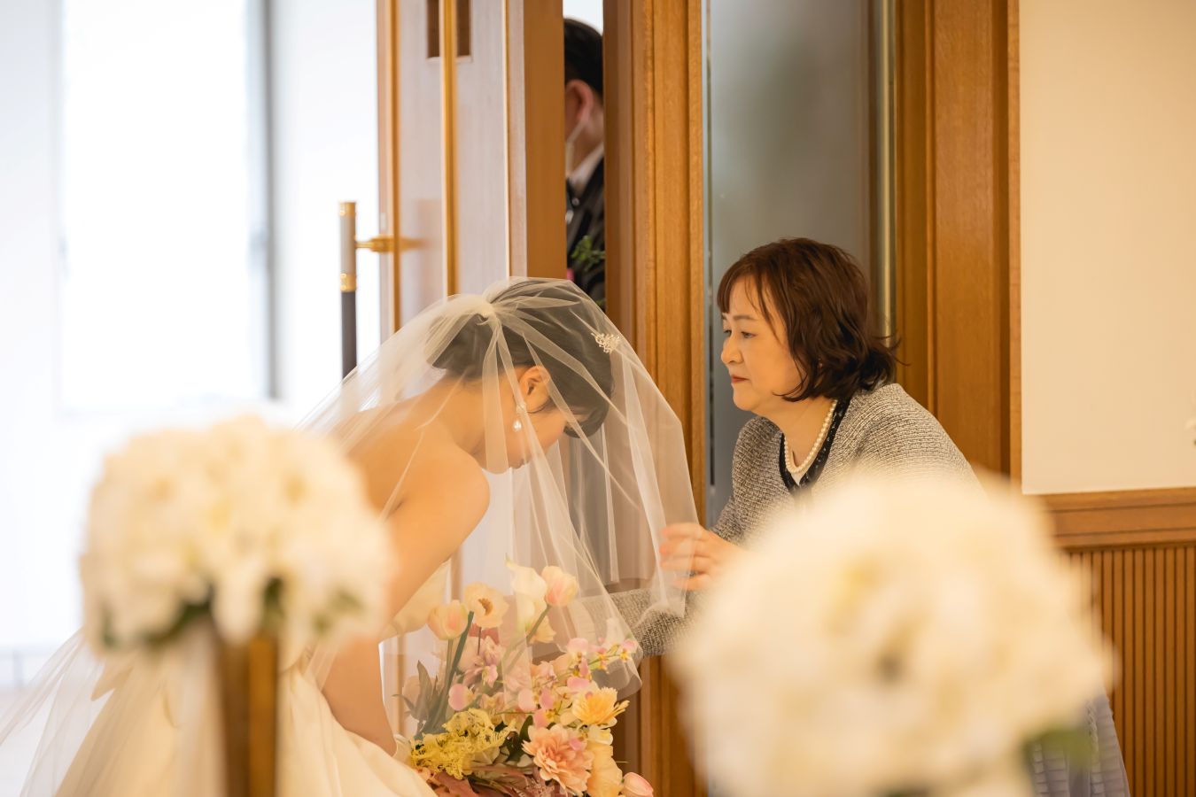 ANAクラウンプラザホテル松山でご結婚式を挙げられたお客様の写真　チャペルでお母様からベールダウンをしてもらうウェディングドレス姿の新婦様