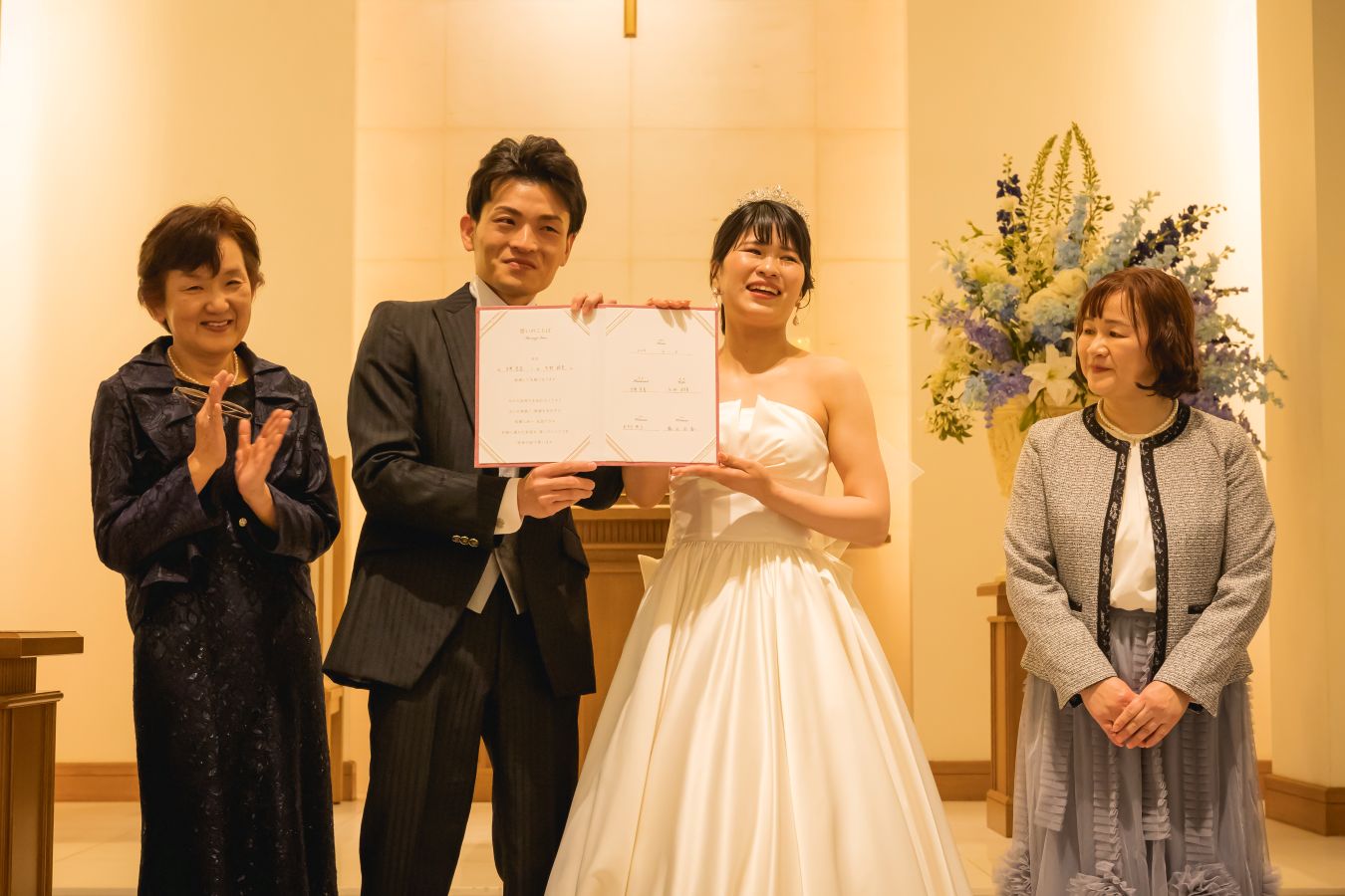 ANAクラウンプラザホテル松山でご結婚式を挙げられたお客様の写真　結婚証明書を親御様と披露するタキシードウェディングドレス姿の新郎新婦様