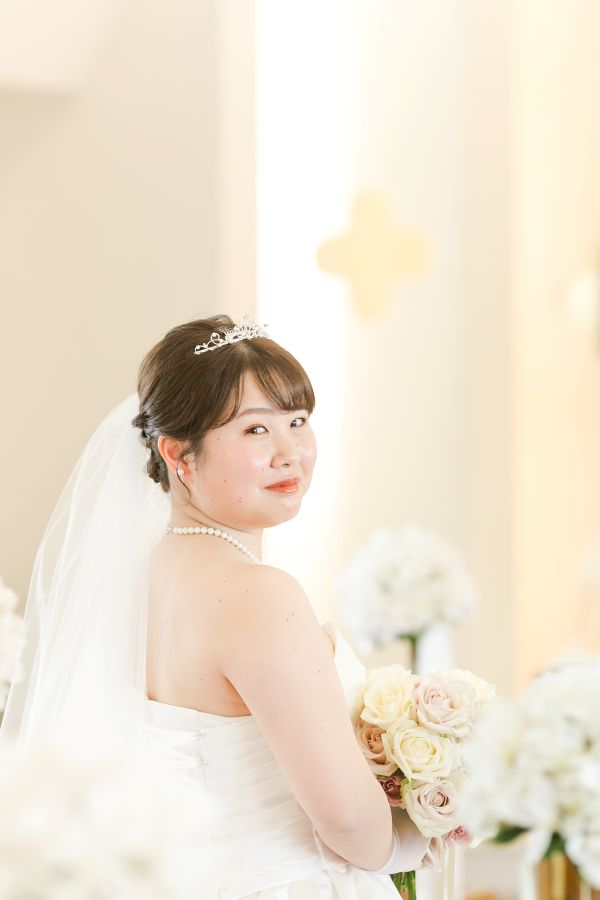 ANAクラウンプラザホテル松山でご結婚式を挙げられたお客様の写真　生花ブーケを持って振り返るウェディングドレス姿の新婦様
