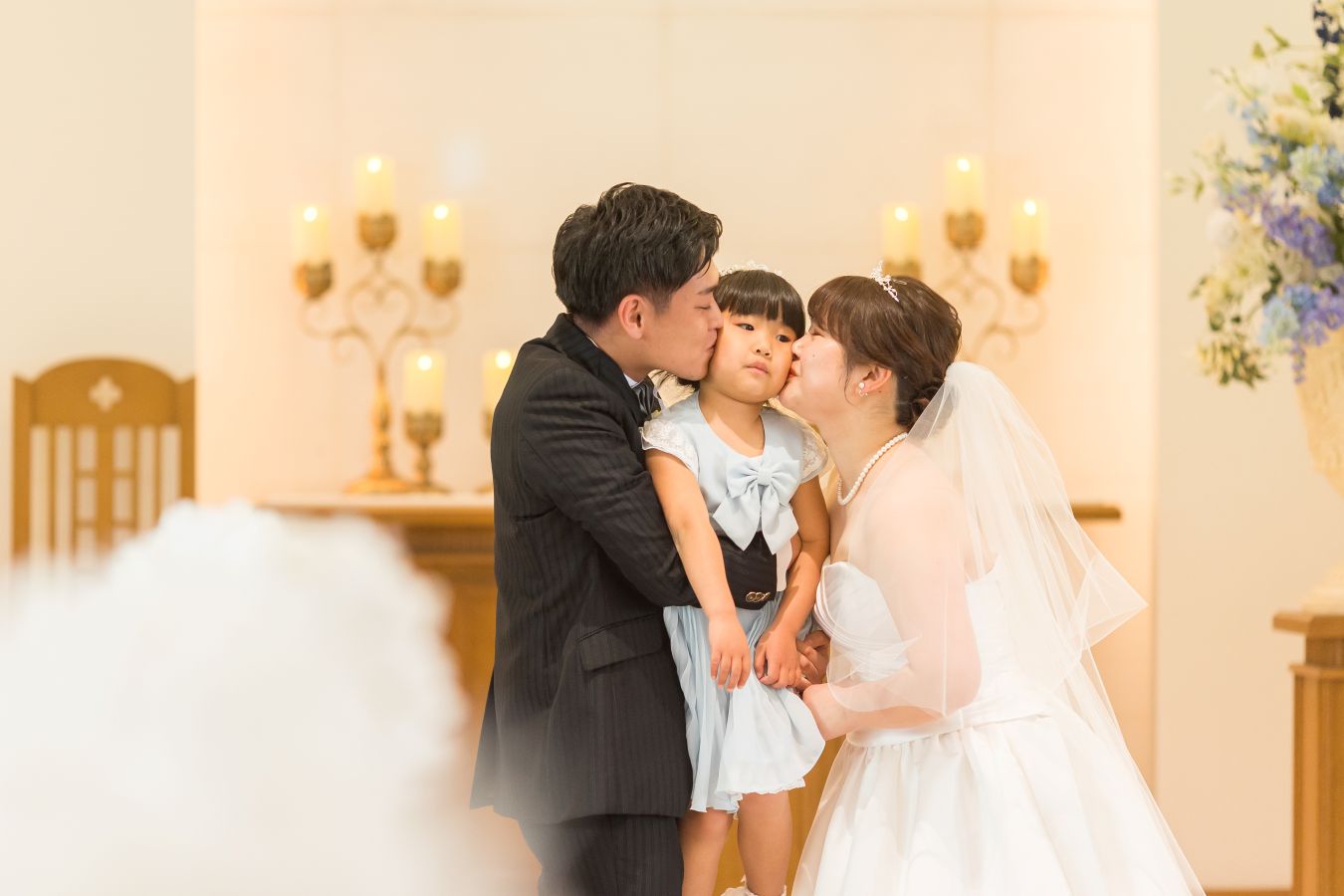 ANAクラウンプラザホテル松山でご結婚式を挙げられたお客様の写真　ファミリーキスをするタキシードウェディングドレス姿の新郎新婦様とお子様