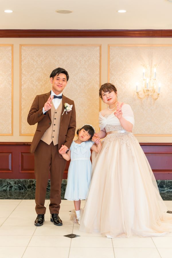 ANAクラウンプラザホテル松山でご結婚式を挙げられたお客様の写真　お色直しをしたタキシードカラードレス姿でお子様と写真を撮る新郎新婦様