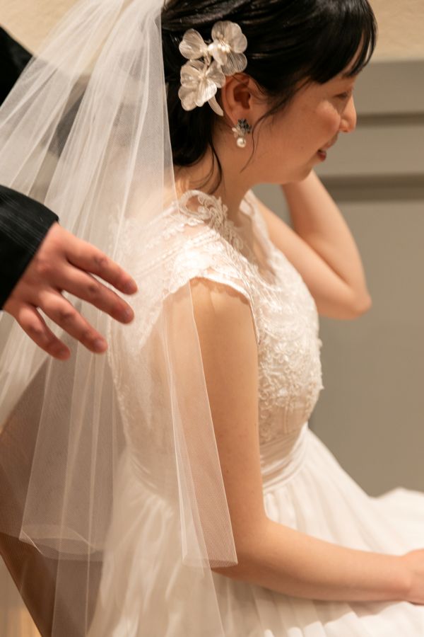 HOTEL LEPO CAHAL レストランAINOでご結婚式を挙げられたお客様の写真　お仕度ができてベールを整えてもらっているウェディングドレス姿の新婦様