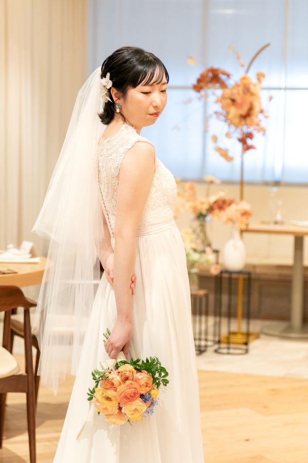 HOTEL LEPO CAHAL レストランAINOでご結婚式を挙げられたお客様の写真　レストラン内でお写真を撮る生花ブーケを持ったウェディングドレス姿の新婦様