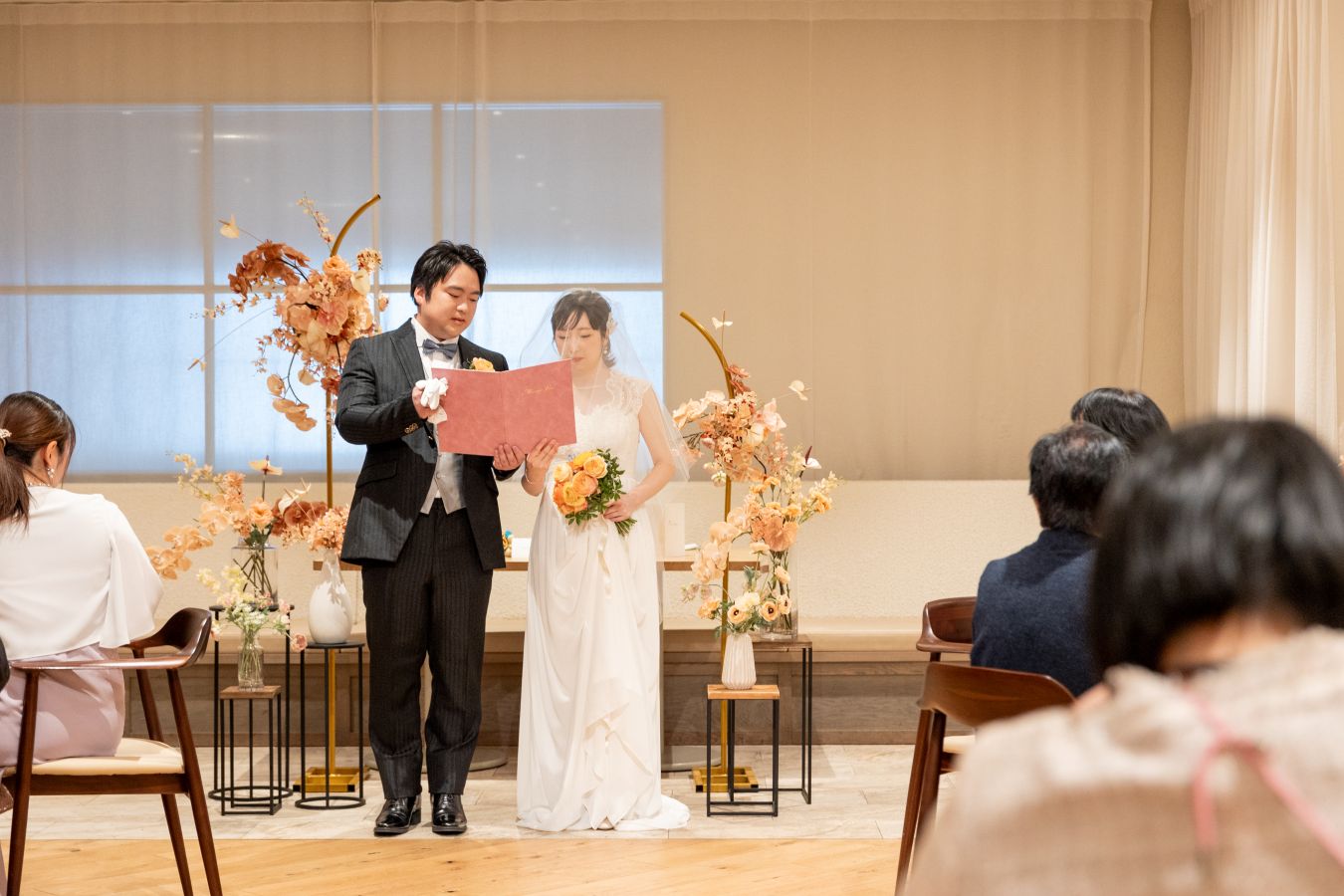 HOTEL LEPO CAHAL レストランAINOでご結婚式を挙げられたお客様の写真　誓いの言葉を読むタキシードウェディングドレス姿の新郎新婦様