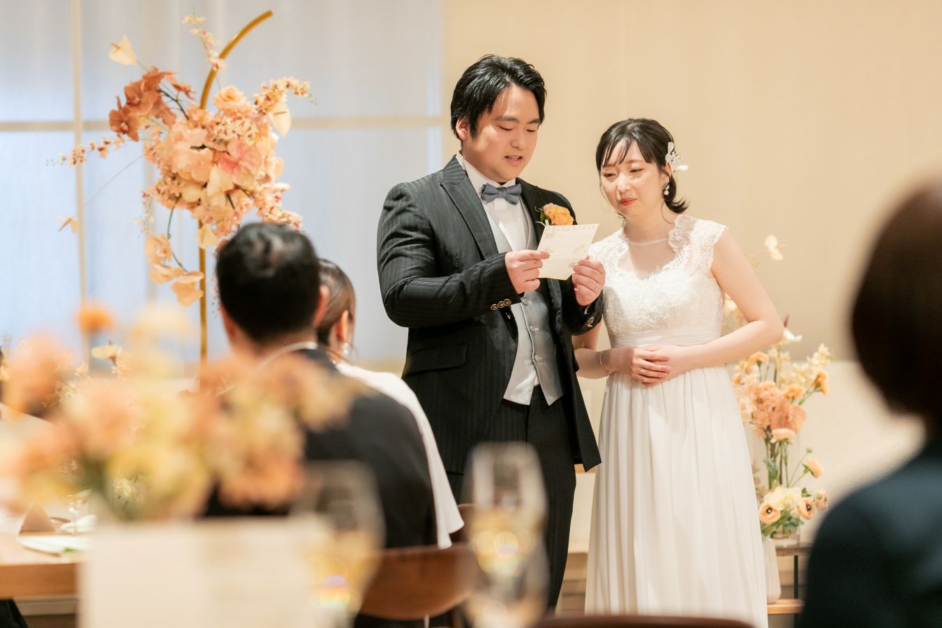 HOTEL LEPO CAHAL レストランAINOでご結婚式を挙げられたお客様の写真　ウェルカムスピーチを読むタキシードウェディングドレス姿の新郎新婦様