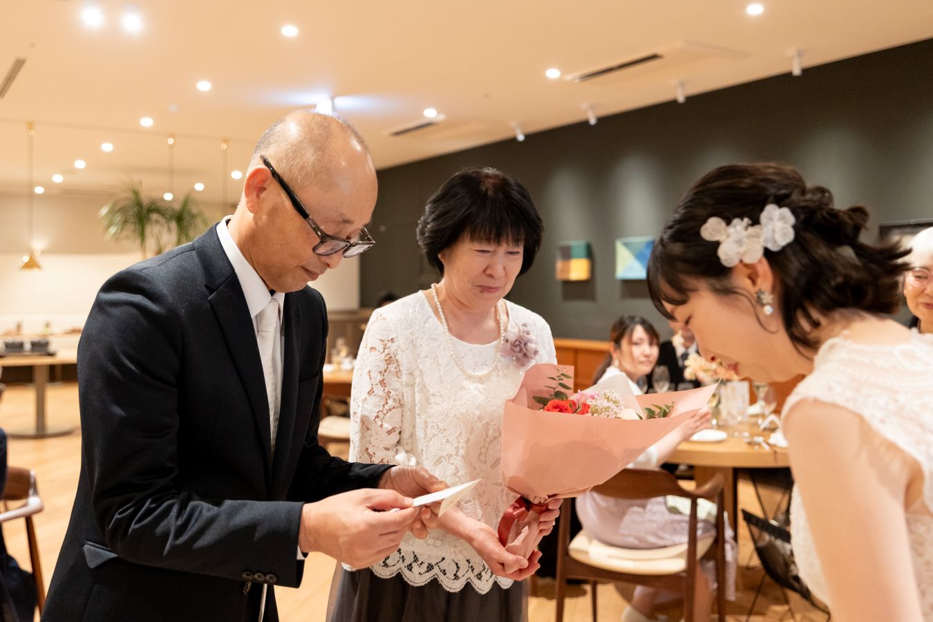 HOTEL LEPO CAHAL レストランAINOでご結婚式を挙げられたお客様の写真　ご両親様へ感謝のお気持ちを花束とともに伝えた新婦様