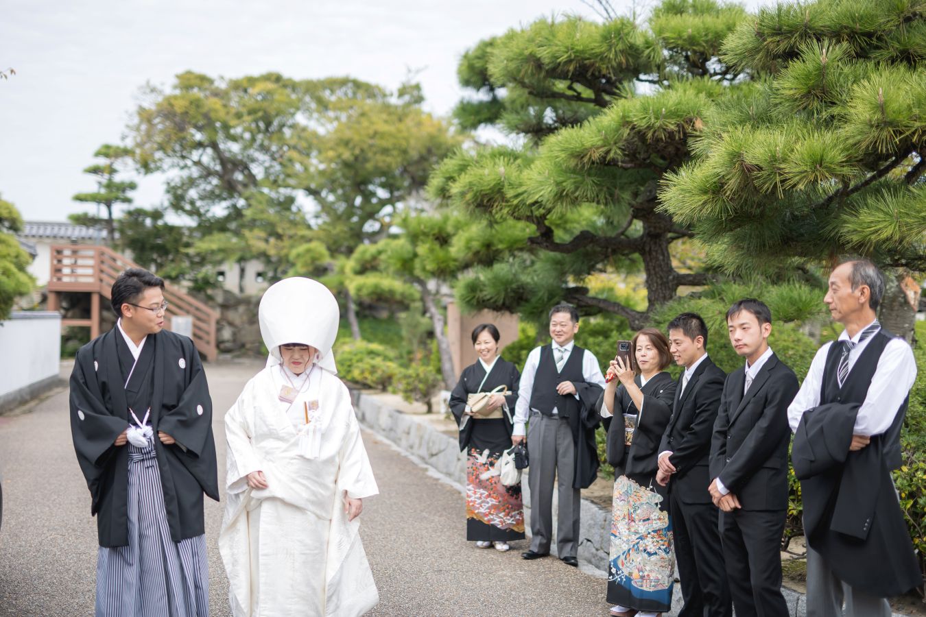今治城内鎮座 吹揚神社で挙げられたお客様の結婚式写真　ご家族様に見守られ神社へと移動する紋付袴白無垢姿の新郎新婦様