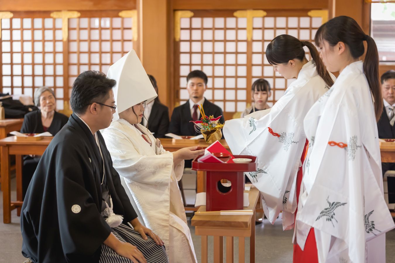 今治城内鎮座 吹揚神社で挙げられたお客様の結婚式写真　神前式で三々九度をする紋付袴白無垢姿の新郎新婦様