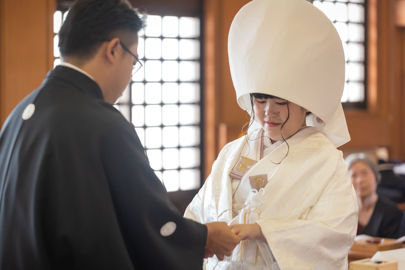 今治城内鎮座 吹揚神社で挙げられたお客様の結婚式写真　神前式で指輪の交換している紋付袴白無垢姿の新郎新婦様