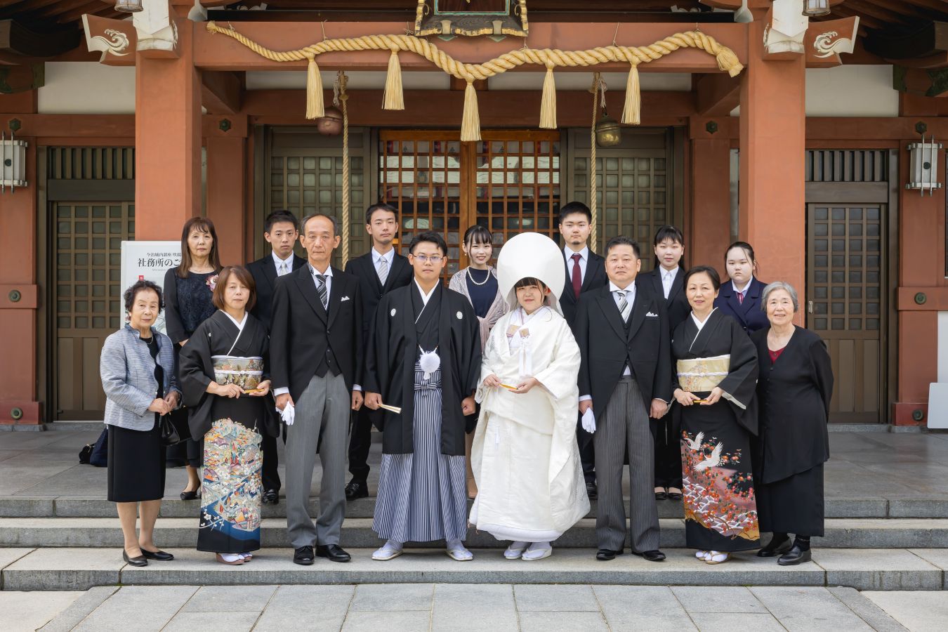今治城内鎮座 吹揚神社で挙げられたお客様の結婚式写真　神社の前で家族写真を撮る紋付袴白無垢姿の新郎新婦様