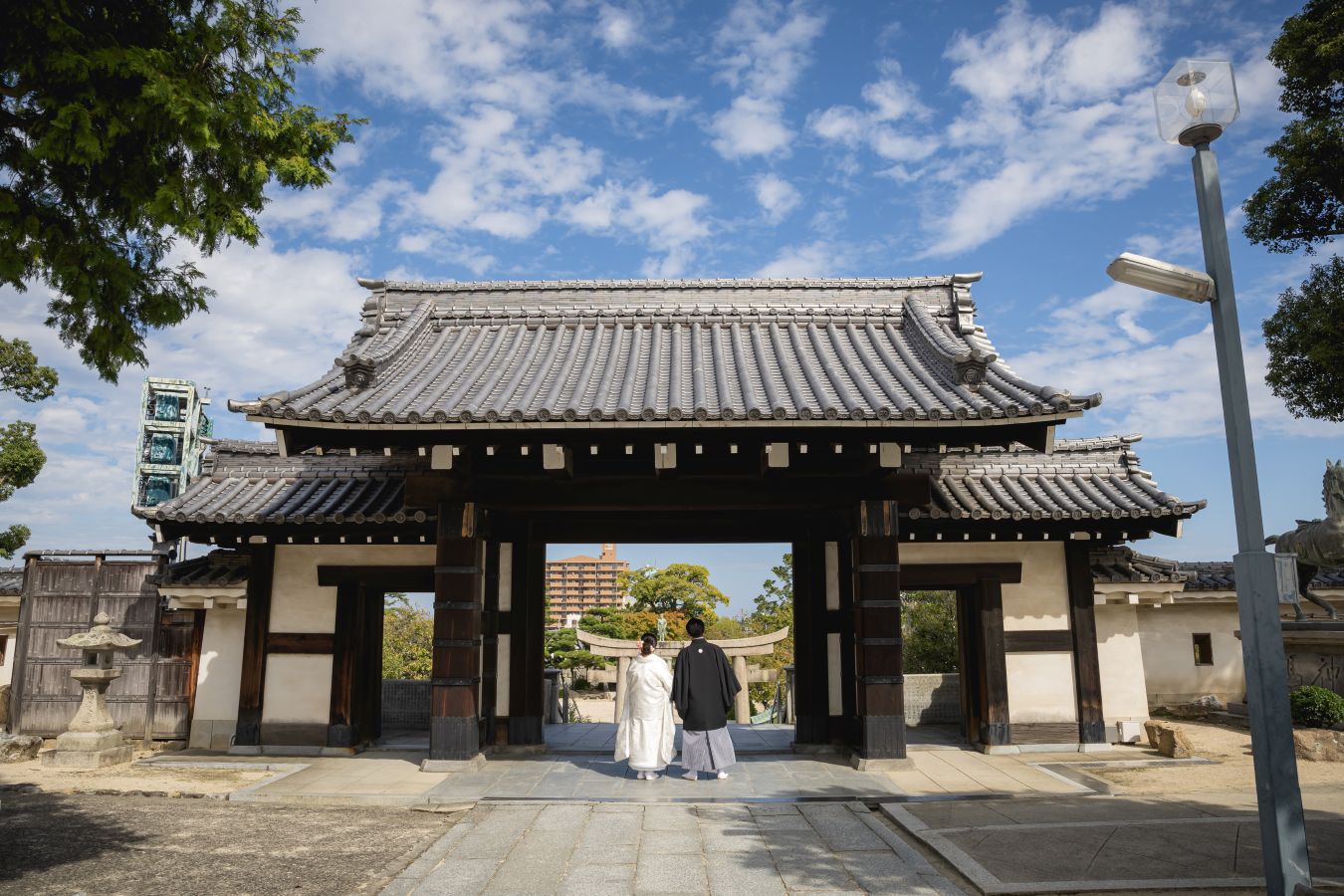 今治城内鎮座 吹揚神社で挙げられたお客様の結婚式写真　紋付袴白無垢姿の新郎新婦様の後ろ姿