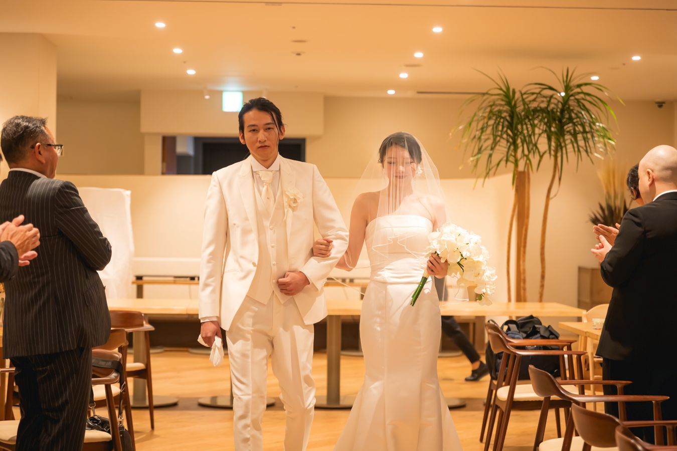 HOTEL LEPO CAHAL レストランAINOでご結婚式を挙げられたお客様の写真　ご家族様に見守られご入場されるタキシードウェディングドレス姿の新郎新婦様