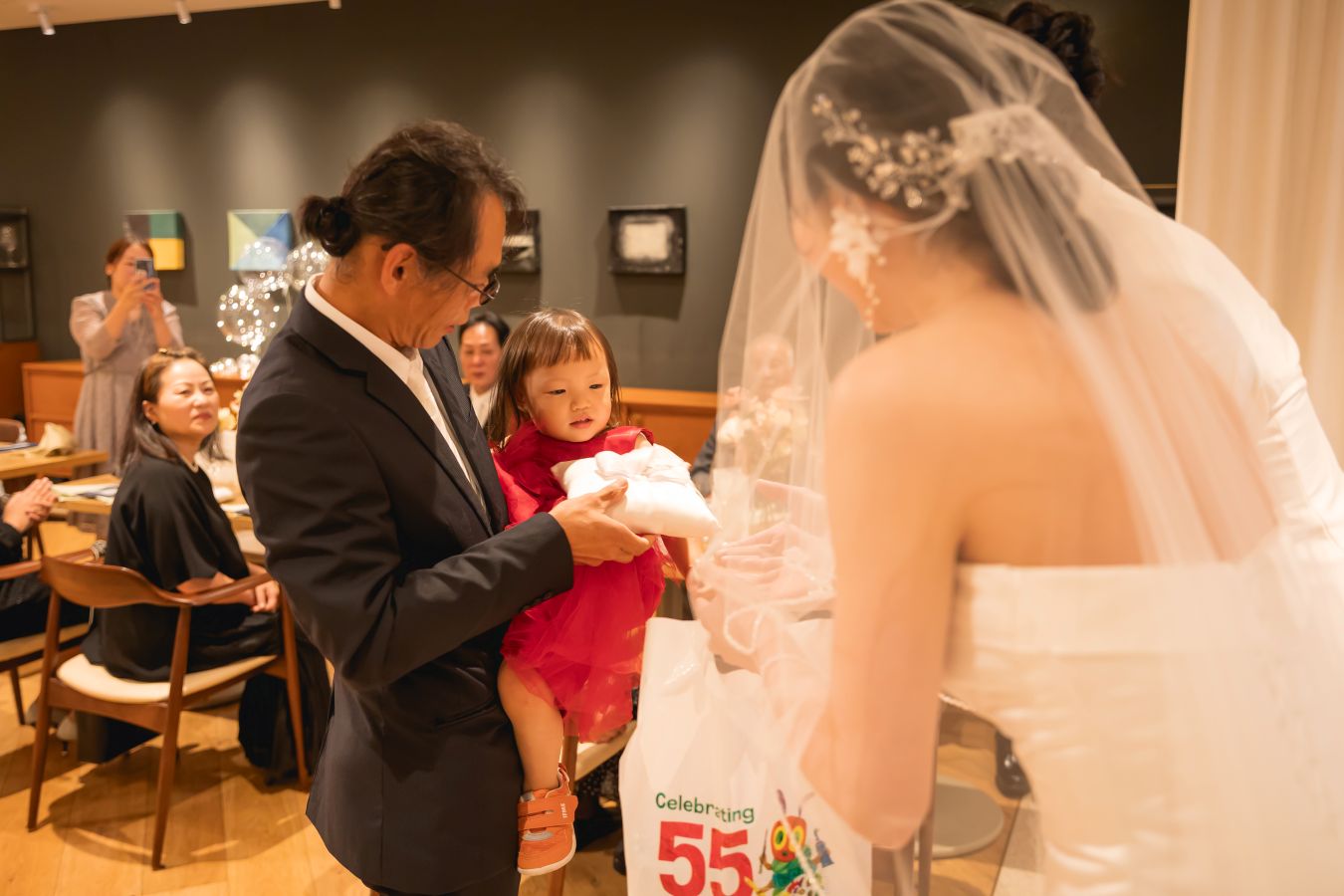 HOTEL LEPO CAHAL レストランAINOでご結婚式を挙げられたお客様の写真　指輪を運んでくれたリングガールにプレゼントをお渡しするタキシードウェディングドレス姿の新郎新婦様