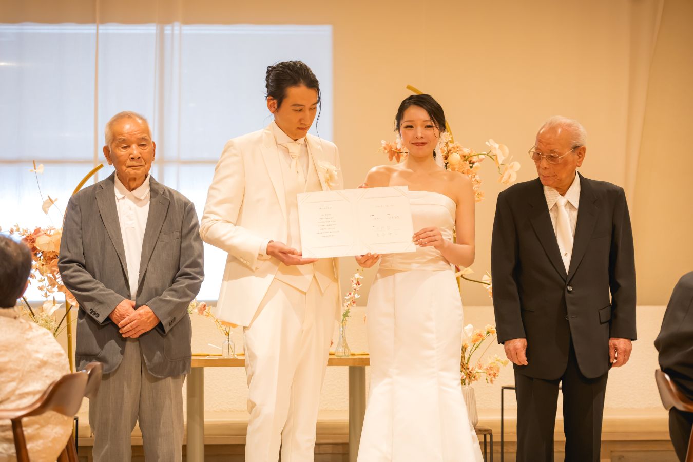 HOTEL LEPO CAHAL レストランAINOでご結婚式を挙げられたお客様の写真　代表立会人で署名をしてもらったおじい様と証明書のご披露をするタキシードウェディングドレス姿の新郎新婦様