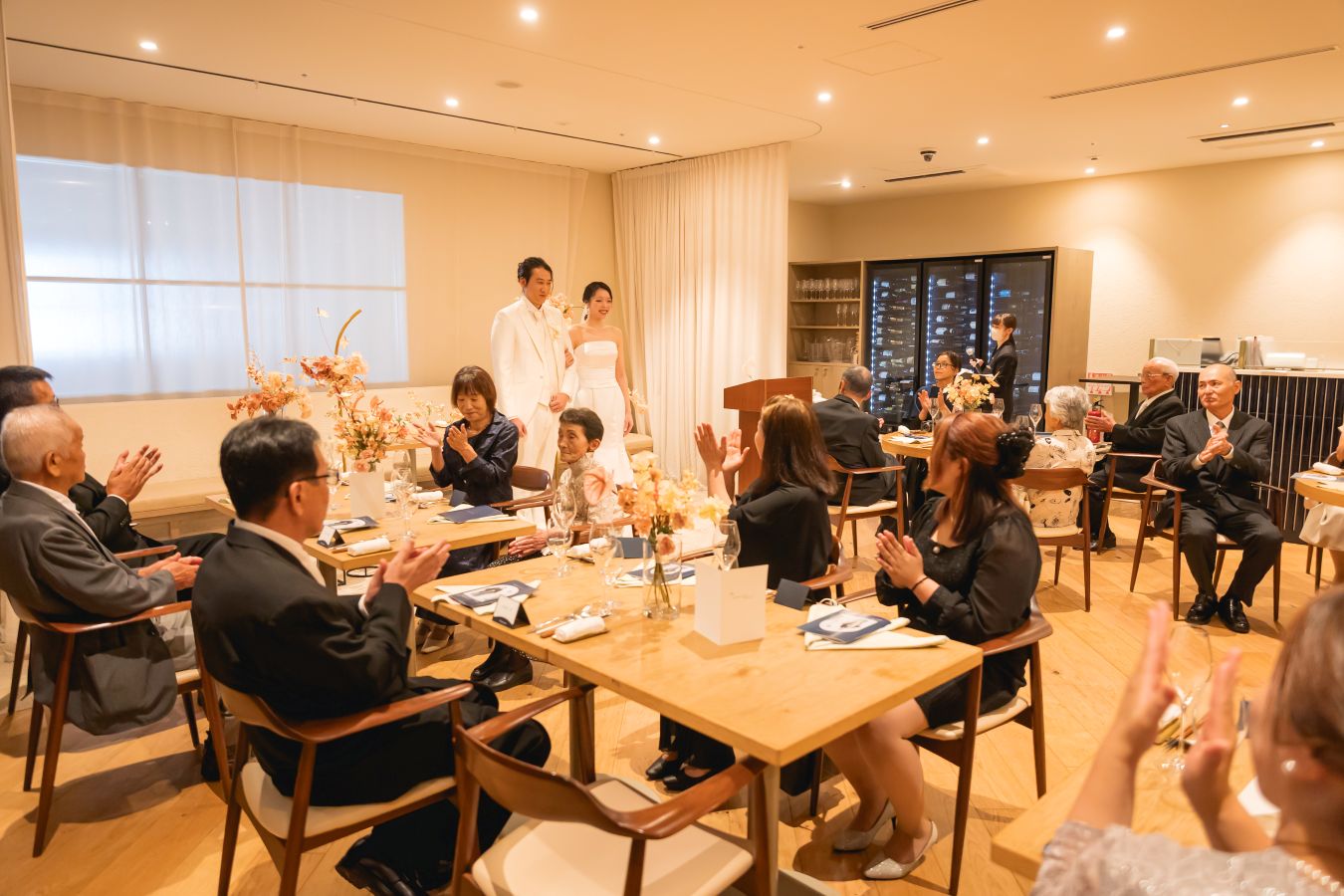 HOTEL LEPO CAHAL レストランAINOでご結婚式を挙げられたお客様の写真　ご家族様から結婚の承認を拍手でいただくタキシードウェディングドレス姿の新郎新婦様
