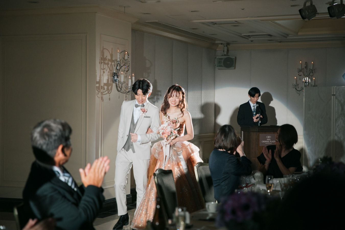 ANAクラウンプラザホテル松山でご結婚式を挙げられたお客様の写真　笑顔でご退場されるタキシードカラードレス姿の新郎新婦様