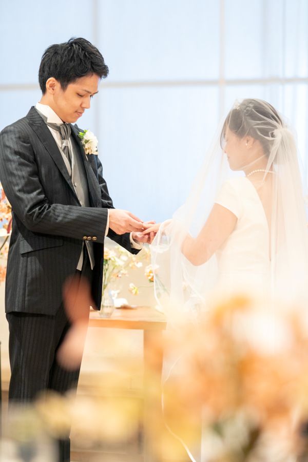 HOTEL LEPO CAHAL レストランAINOでご結婚式を挙げられたお客様の写真　宴内人前式で指輪の交換をするタキシードウェディングドレス姿の新郎新婦様