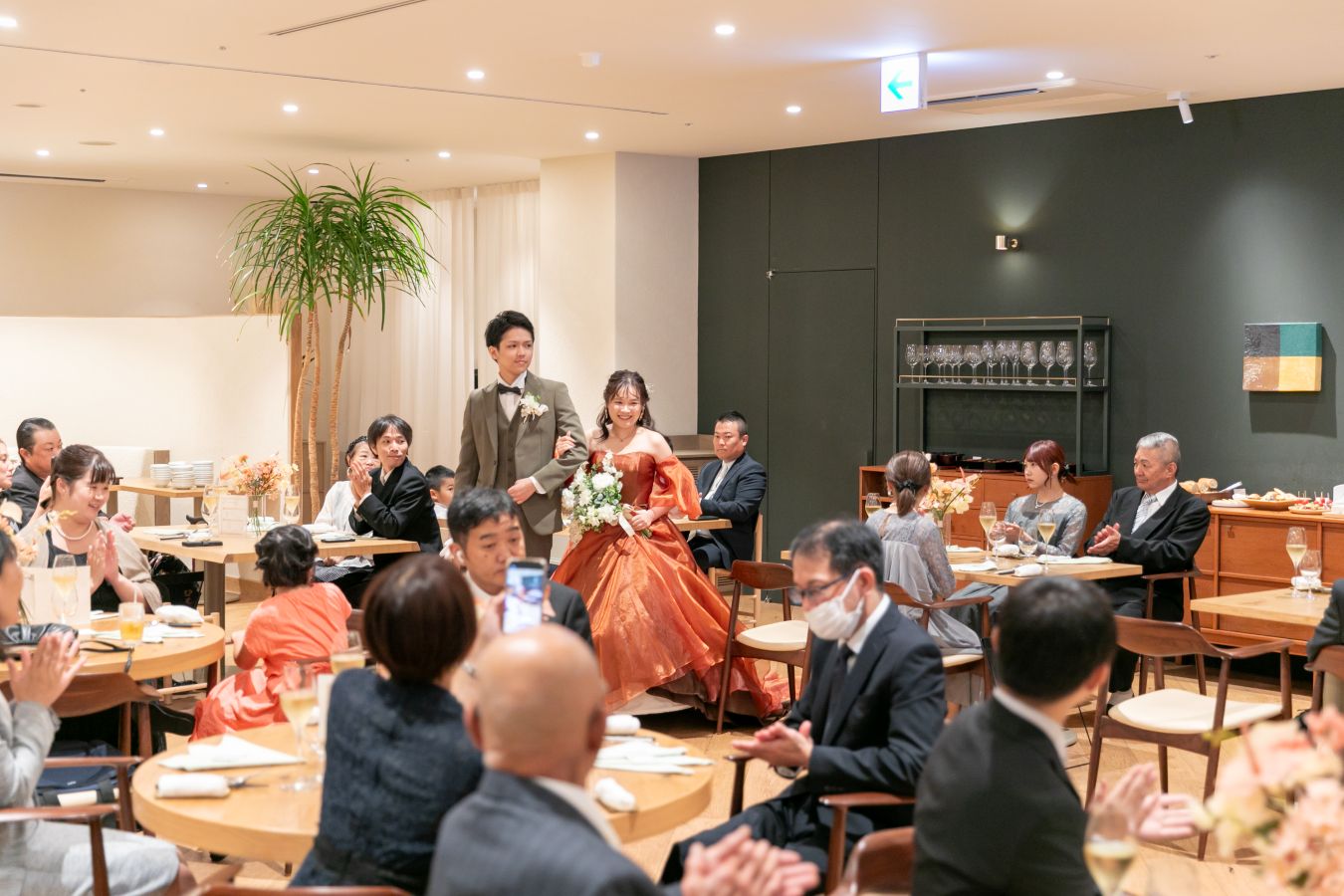 HOTEL LEPO CAHAL レストランAINOでご結婚式を挙げられたお客様の写真　お色直し後笑顔でご入場されるタキシードカラードレス姿の新郎新婦様