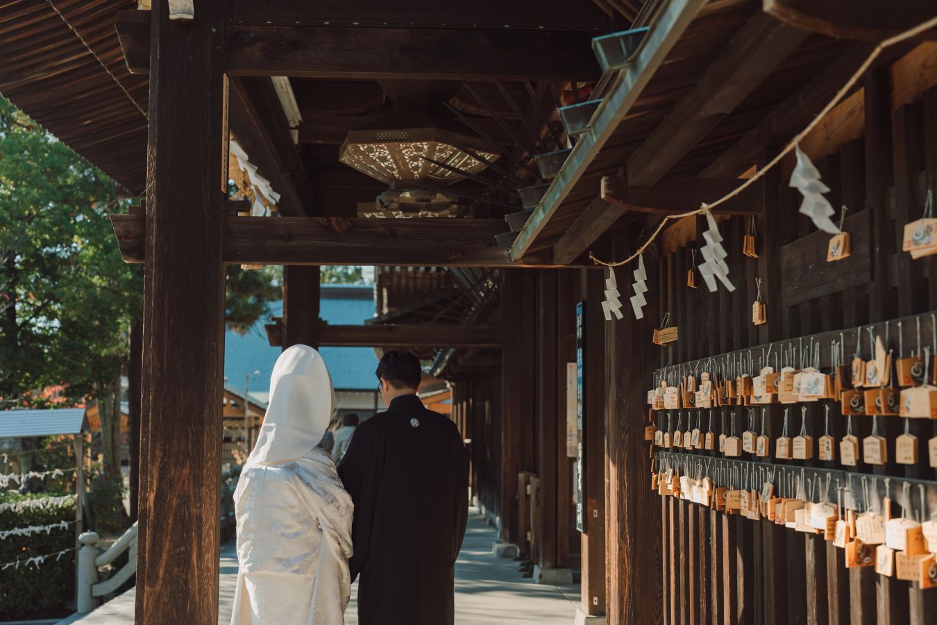 愛媛縣護國神社でご結婚式を挙げられたお客様の写真　リハーサルに備えてご準備される紋付袴白無垢の新郎新婦様の後ろ姿