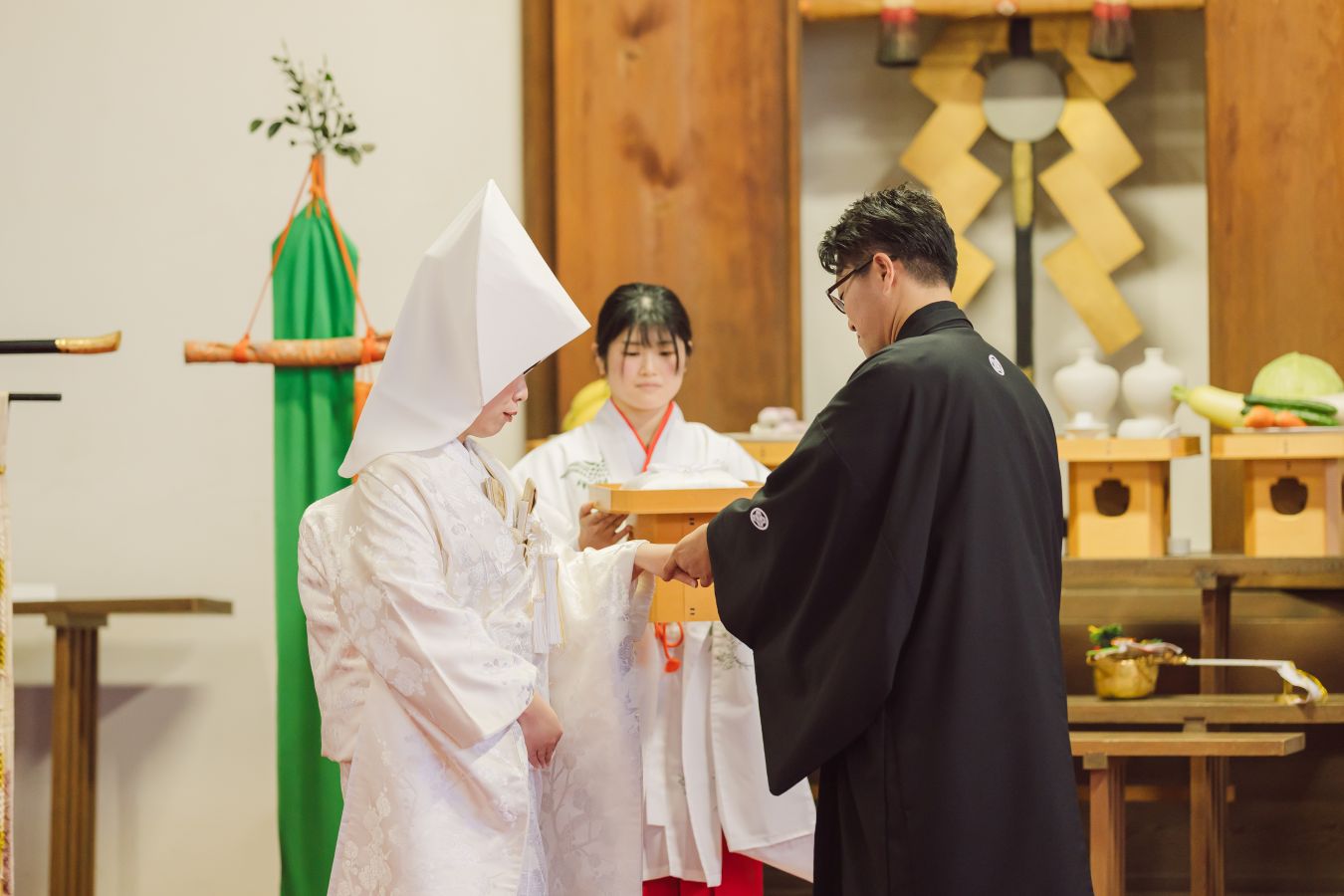 愛媛縣護國神社でご結婚式を挙げられたお客様の写真　神前式で指輪の交換をする紋付袴白無垢姿の新郎新婦様