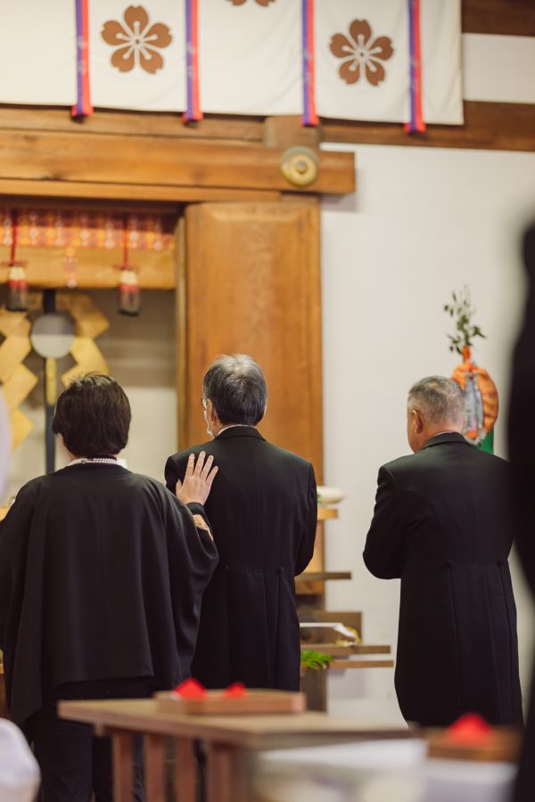 愛媛縣護國神社でご結婚式を挙げられたお客様の写真　ご両家代表玉串奉奠をしているご両家のお父様の後ろ姿