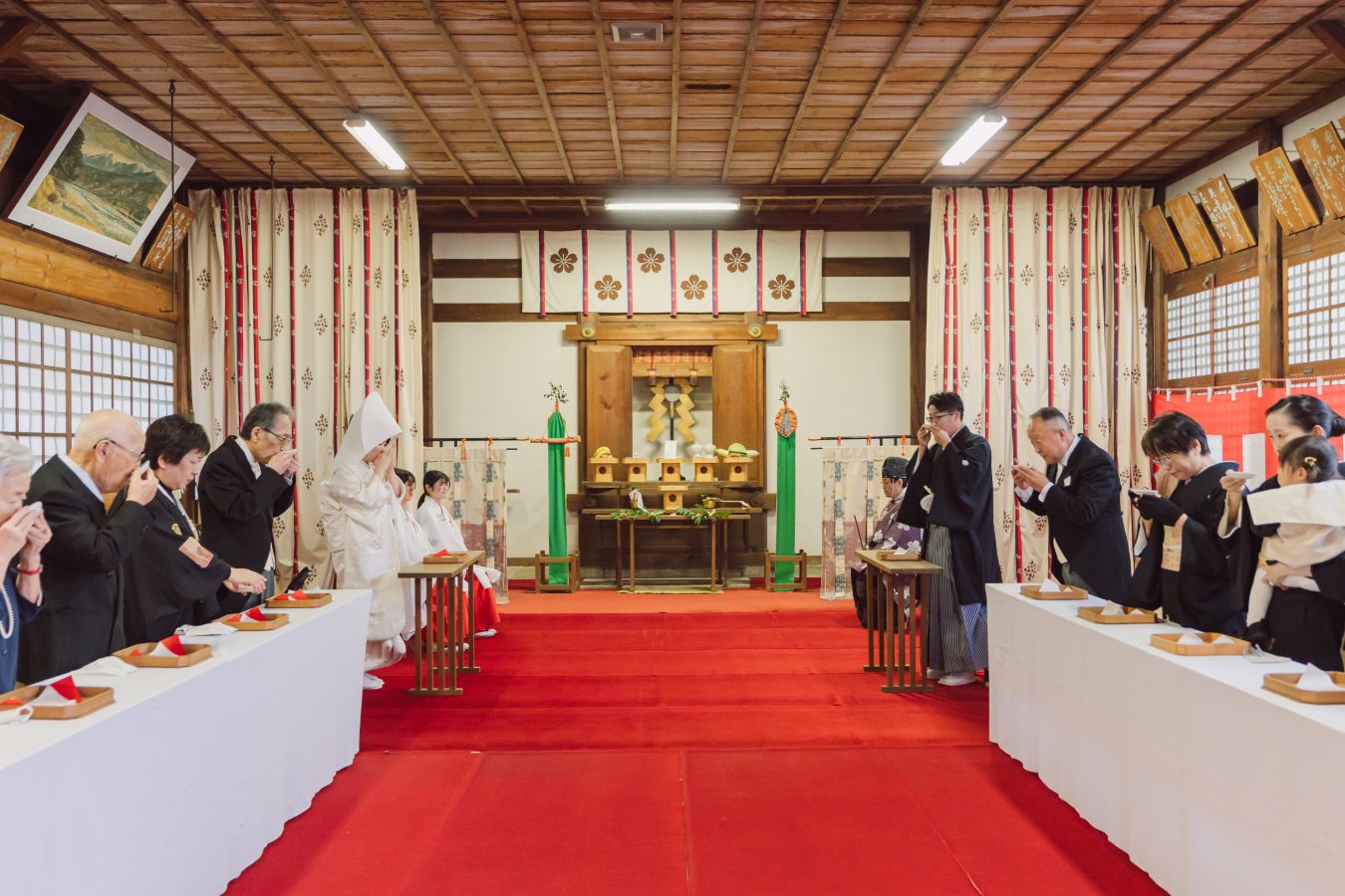 愛媛縣護國神社でご結婚式を挙げられたお客様の写真　親族固めの盃を行う新郎新婦様とご家族の皆様