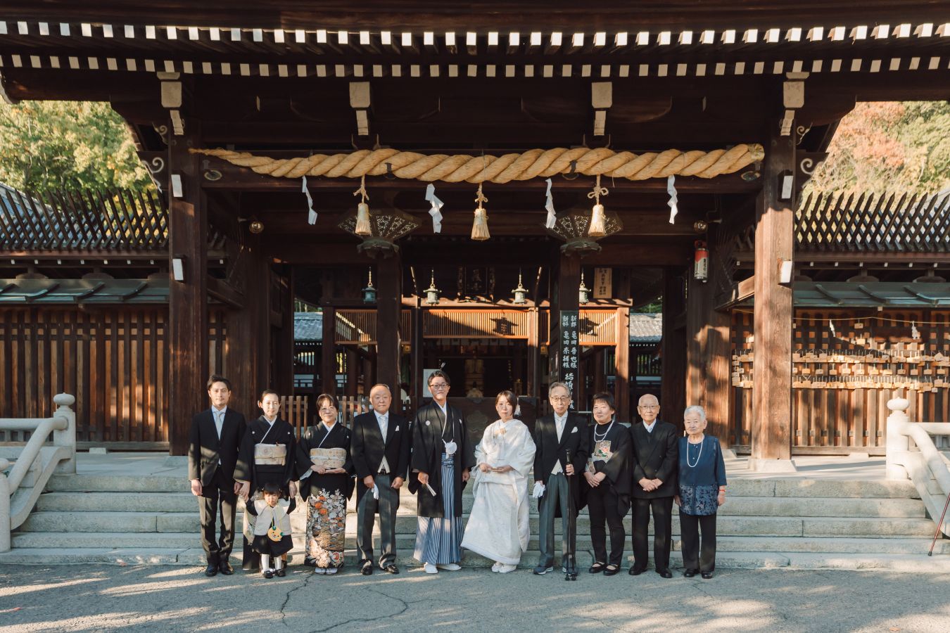 愛媛縣護國神社でご結婚式を挙げられたお客様の写真　神社の前でご家族集合写真を撮る新郎新婦様
