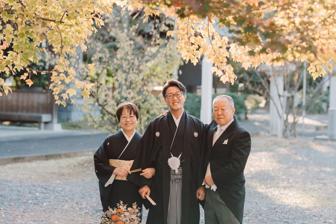 愛媛縣護國神社でご結婚式を挙げられたお客様の写真　ご両親様と笑顔でお写真に写る紋付袴姿の新郎様