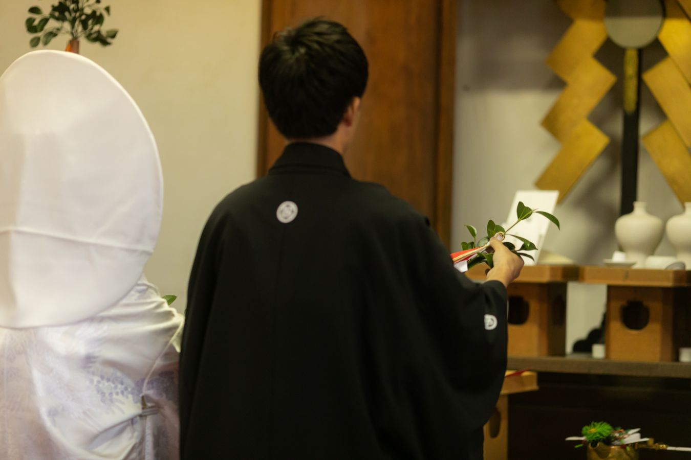 愛媛縣護國神社でご結婚式を挙げられたお客様の写真　玉串奉奠をする紋付袴白無垢姿の新郎新婦様