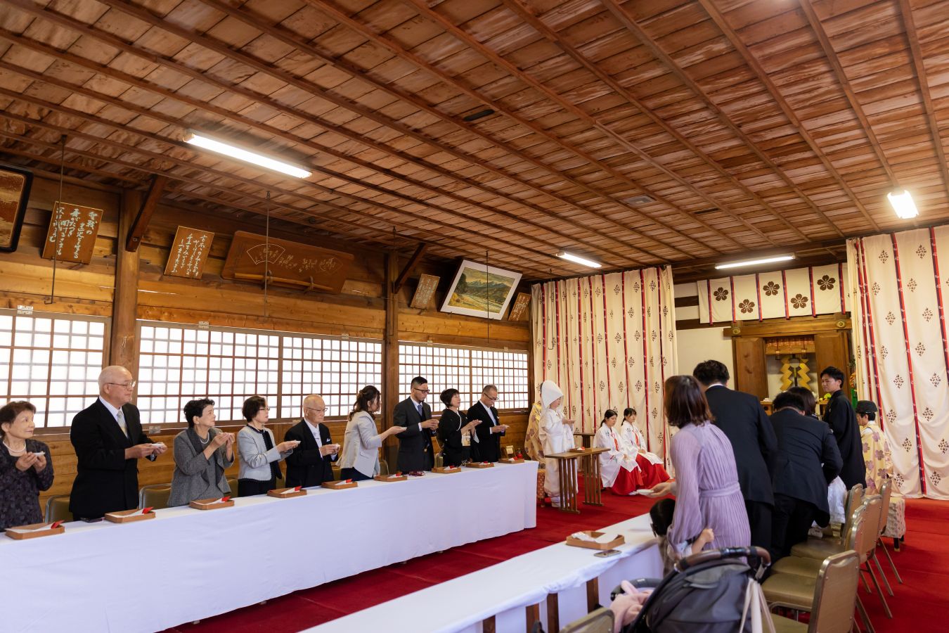愛媛縣護國神社でご結婚式を挙げられたお客様の写真　親族固めの盃をする新郎新婦様とご家族の皆様