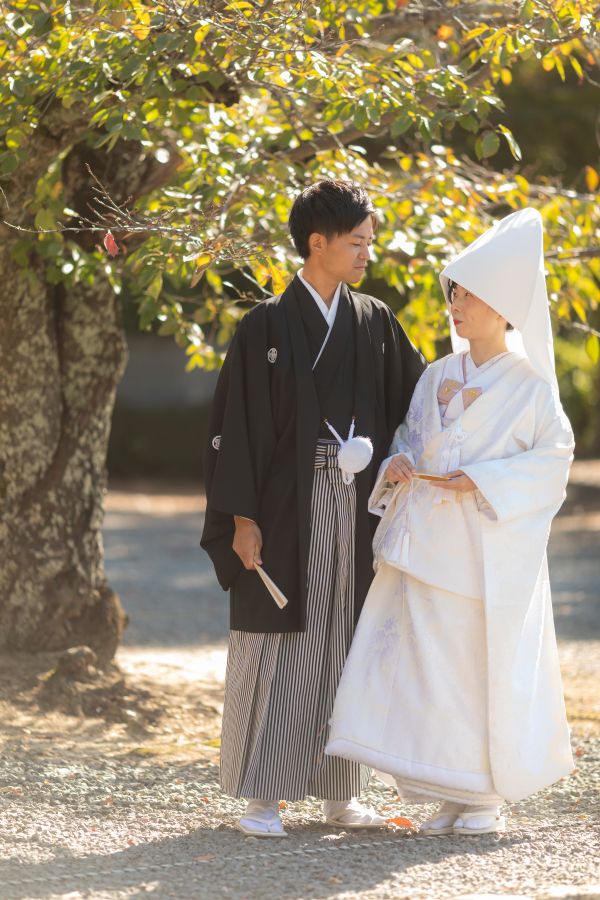 愛媛縣護國神社でご結婚式を挙げられたお客様の写真　神前式後お写真を撮る紋付袴白無垢姿の新郎新婦様