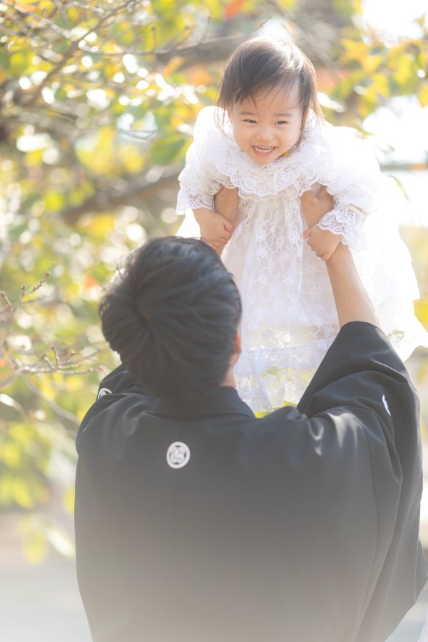 愛媛縣護國神社でご結婚式を挙げられたお客様の写真　お子様と遊ぶ紋付姿の新郎様