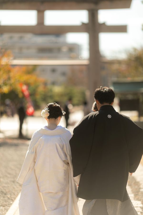 愛媛縣護國神社でご結婚式を挙げられたお客様の写真　神社を後にする新郎新婦様の後ろ姿
