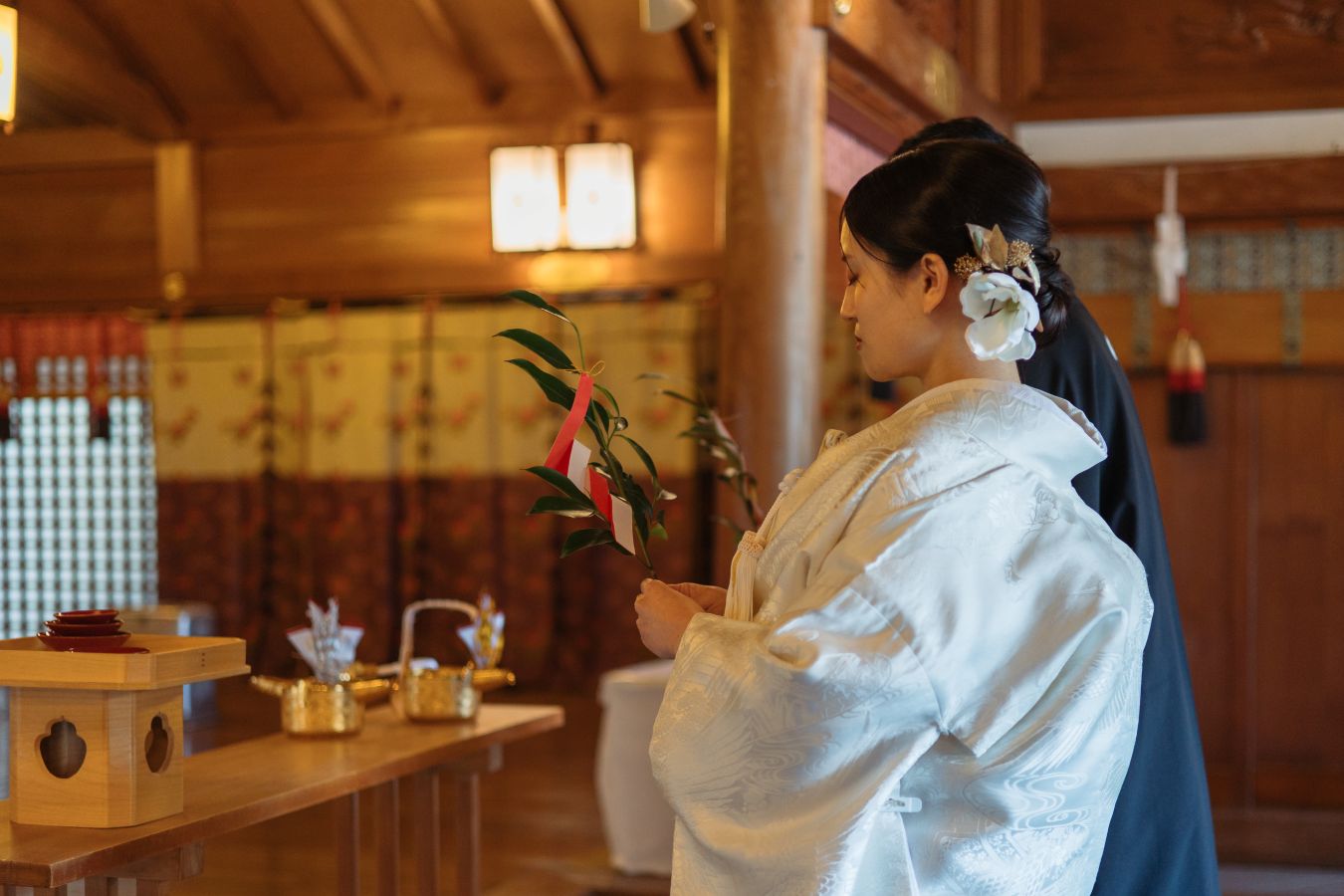 伊豫豆比古命神社　椿祷殿(椿神社)にて結婚式を挙げられたお客様の写真　玉串奉奠をしている紋付袴白無垢姿の新郎新婦様