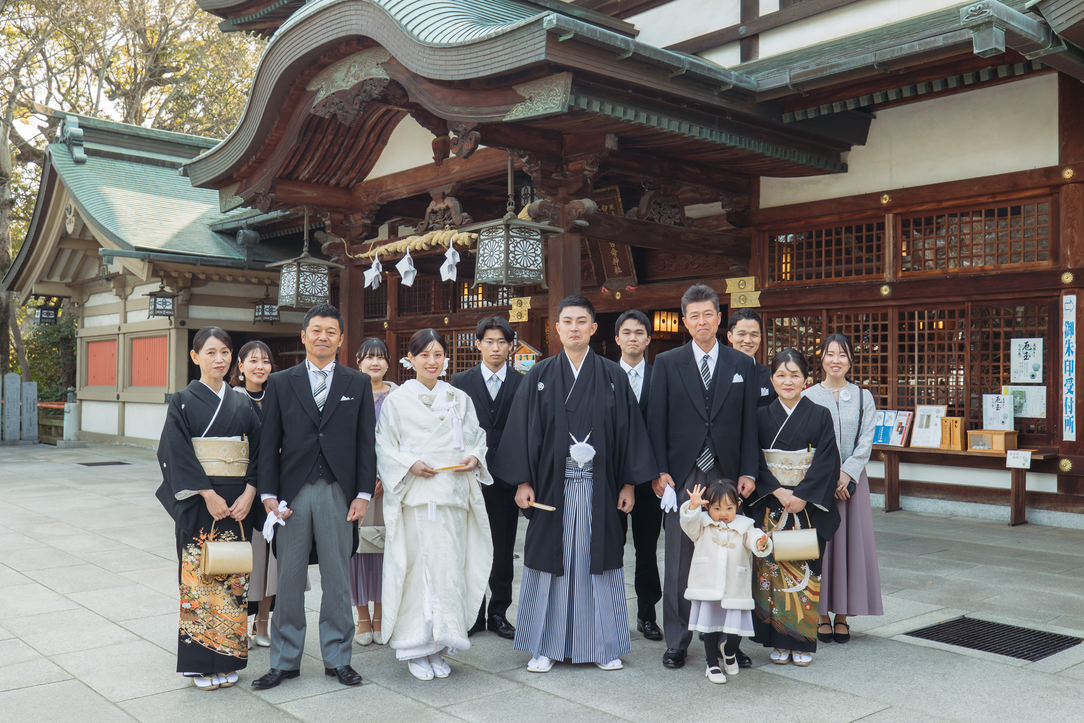 伊豫豆比古命神社 椿祷殿（椿神社）で挙げられたお客様の結婚式神殿の前で家族写真を撮る紋付袴白無垢姿の新郎新婦様
