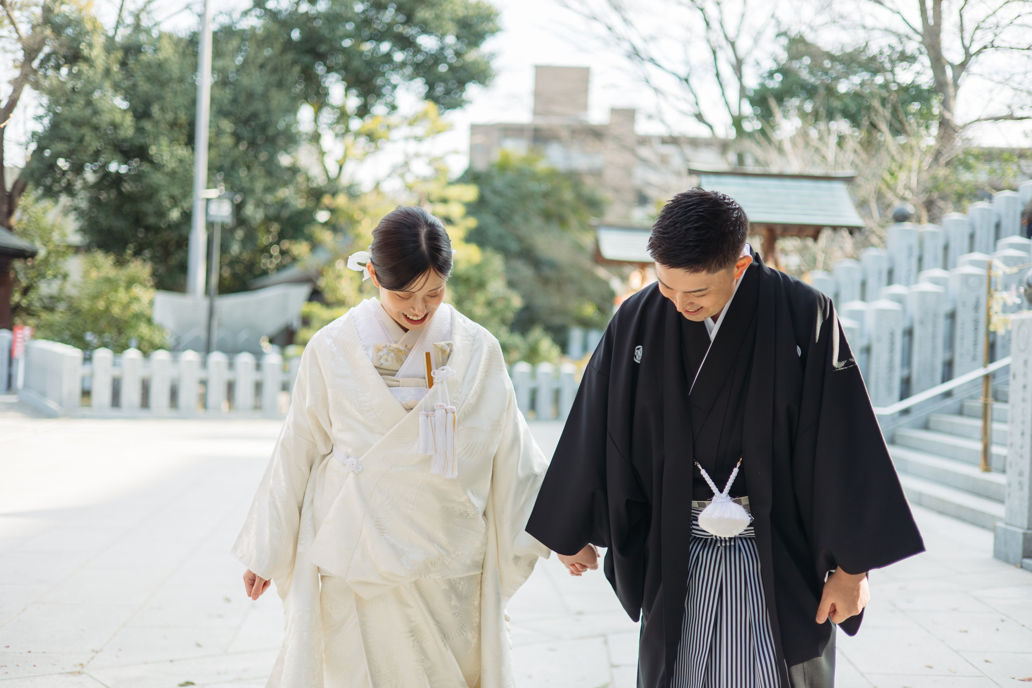 伊豫豆比古命神社 椿祷殿（椿神社）で挙げられたお客様の結婚式　結婚式が結んだあと手をつないでお帰りになる紋付袴白無垢姿の新郎新婦様