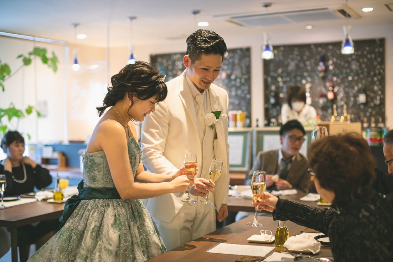 Trattoria Violaでお食事をされたお客様のお写真　ご家族様のテーブルへご挨拶される新郎新婦様