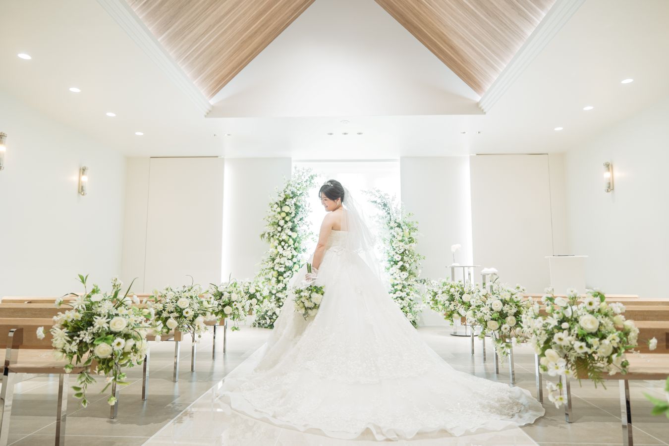 小さな結婚式 松山チャペルで挙げられたお客様の結婚式写真　チャペルでトレーンを広げてウェディングドレスの後ろ姿の撮影