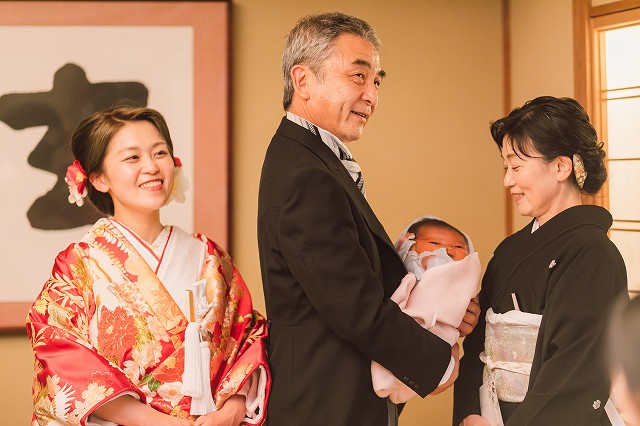 道後うめ乃や　贈呈品を受け取ってやさしい表情のご両親