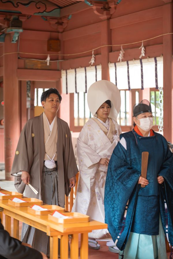 伊佐爾波神社でご結婚式後栴檀でお食事をされたお客様の写真　神前式入場をする紋付袴白無垢姿の新郎新婦様