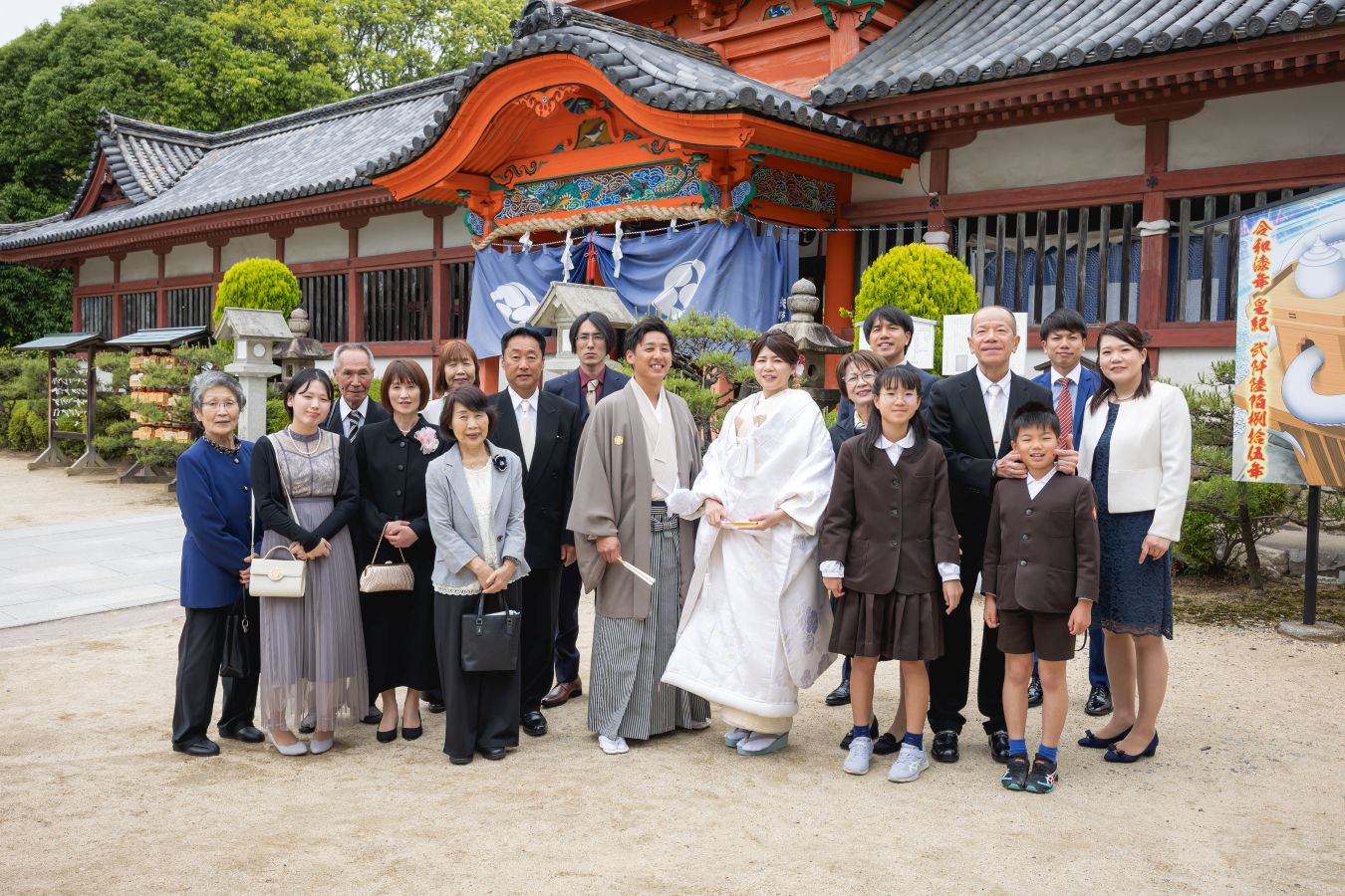伊佐爾波神社でご結婚式後栴檀でお食事をされたお客様の写真　式後リラックスした表情で家族写真を撮る新郎新婦様