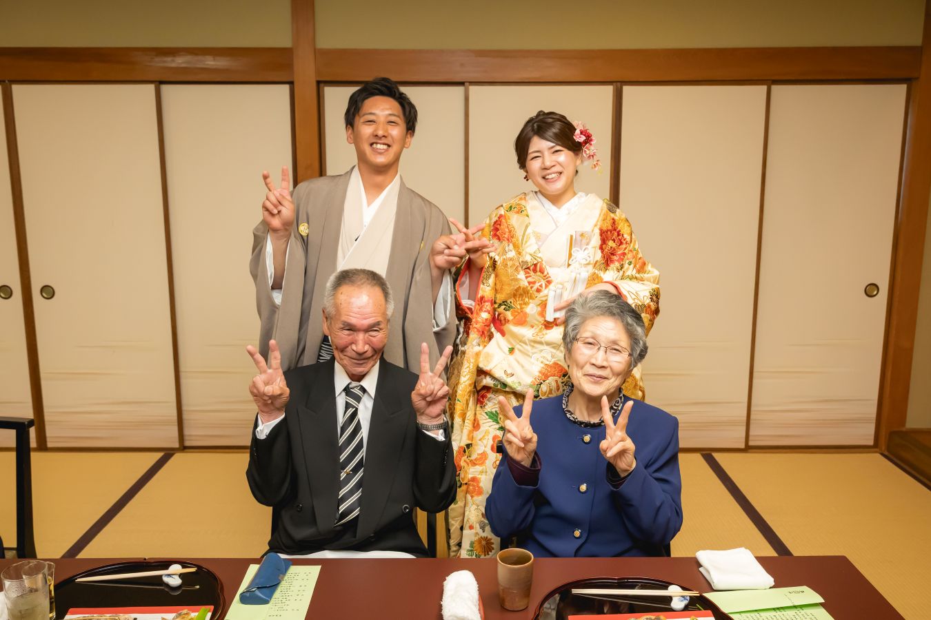 伊佐爾波神社でご結婚式後栴檀でお食事をされたお客様の写真　ご家族様とお写真を撮る新郎新婦様