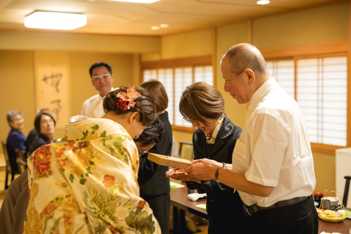 伊佐爾波神社でご結婚式後栴檀でお食事をされたお客様の写真　ご両親様へ三連時計を贈呈する新郎新婦様