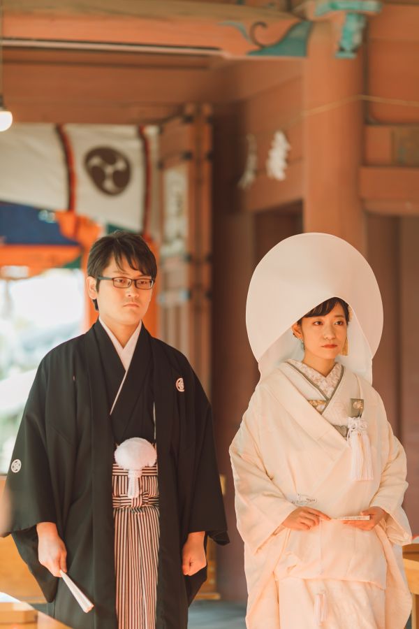 道後うめ乃やでご結婚式を挙げられたお客様の写真　神前式入場をする紋付袴白無垢姿の新郎新婦様
