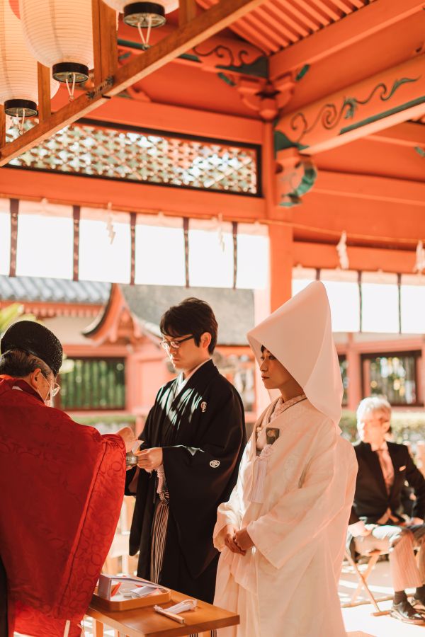 道後うめ乃やでご結婚式を挙げられたお客様の写真　三々九度をしている紋付袴白無垢姿の新郎新婦様